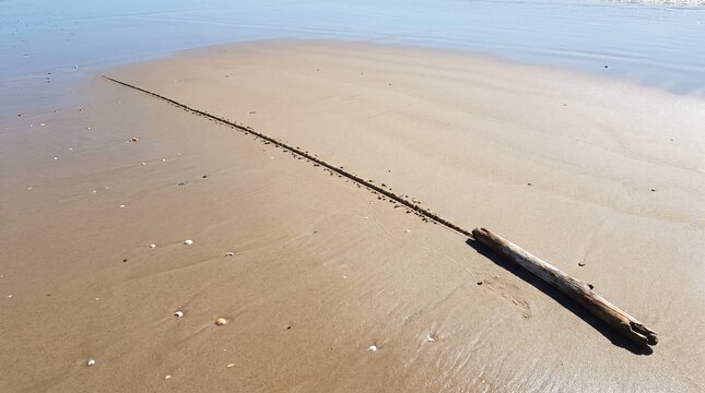 Straight Line Drawn Across Smooth Beach Sand as a Boundary and Ultimatum Metaphor
