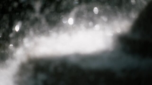勢いよく飛沫を滴らせ落ちる噴水の水しぶき　キラキラ太陽の光を反射して輝く丸ボケ　夏・日本の季節・夏休み・水遊びの風景　