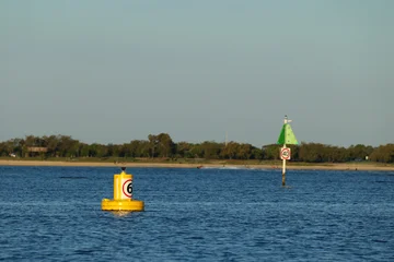 Yellow Navigation Buoy and Speed Limit Sign in Coastal Waterway © blueringmedia