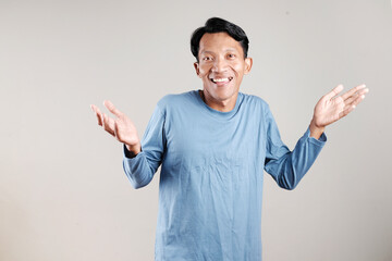 Fototapeta premium Smiling Asian man making various hand gestures isolated on gray background with copy space