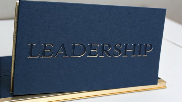 Elegant blue book with embossed word "Leadership" showcasing themes of guidance, inspiration, and personal development concepts
