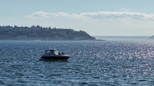 Motorboat Cruising on Sparkling Blue Water with Shoreline Background