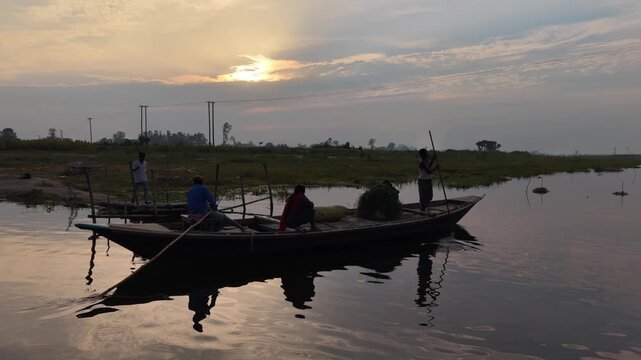 Serene river journey at sunrise silhouettes of people in a traditional boat with cargo reflecting