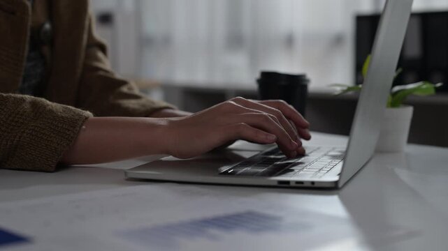 Person Using Laptop Computer for Work or Study in Modern Office Setting