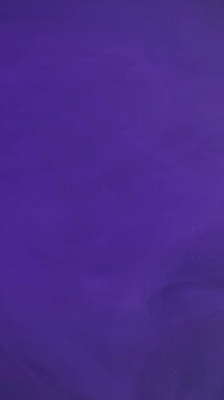 Vertical video. Vapor art. Mist ink. Defocused neon purple color paint in smoke water chemical liquid substance floating on abstract background.