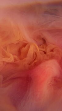 Vertical video. Blur color pigment. Fog ink blend. Defocused orange pink dust lens flare rainbow splash cloud spreading on abstract underwater background.