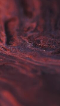 Vertical video. Paint wave. Glitter mix. Defocused orange purple color in water grain texture marble liquid floating on abstract background.