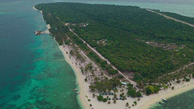 Aerial drone shot descending towards Punta Sebaring on Bugsuk Island in Balabac Palawan Philippines revealing white sand beach campsites and turquoise shallow water