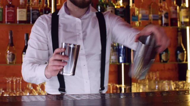 Barman occupation. Cocktail drink. Skillful male expert hands making fresh alcohol beverage using shaker on bar counter.