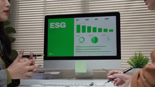 Focused businesswoman analyzing green computer chart during corporate presentation meeting about office sustainability strategy
