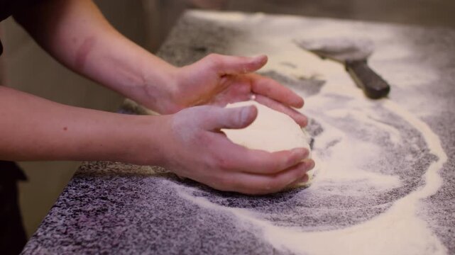 Cooking pastries. Dough preparation. Unrecognizable experienced chef hands shaping on floured work surface professional table in kitchen.