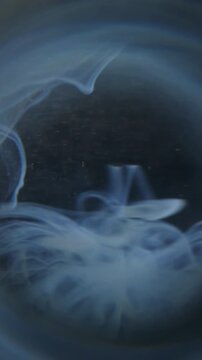 Vertical video. Wave cloud blur. Water ink. Blue gray circle prism swirling splash. Dark color haze dye drop mixing in liquid abstract black background.
