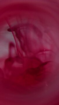 Vertical video. Wave cloud blur. Water ink. Red white circle prism swirling splash. Bright color haze dye drop mixing in liquid abstract background.