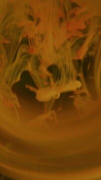 Vertical video. Blur fume explosion. Ink blob. Neon colorful dye dissolving underwater. Art sphere spectrum glow on dark abstract background.