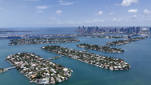 Aerial view of Miami skyline and waterfront islands over turquoise Biscayne Bay in sunny Florida, USA. g.