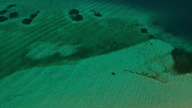 Aerial backward rocket ascent looking straight down over Tangkahan Island, Balabac, Philippines. Reverse climbing top-down drone flight reveals tropical hook sandbar and coral reef.