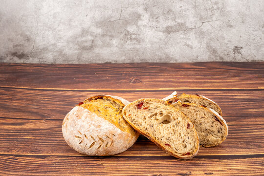 Freshly baked sourdough bread loaf on the wooden and white background with full depth of field. Artisanal or healthy food concept