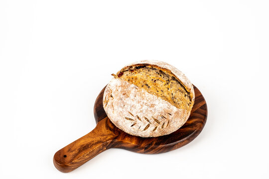 Freshly baked sourdough bread loaf on the board and white background with full depth of field. Artisanal or healthy food concept