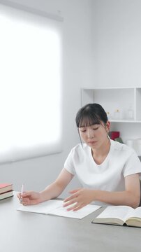 スマホを見ながら勉強する10代女性
