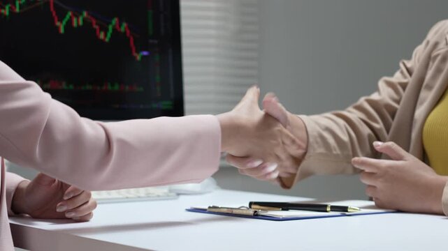 Businesswoman analyzes stock chart during finance meeting, finalizing deal with happy investor in office discussion