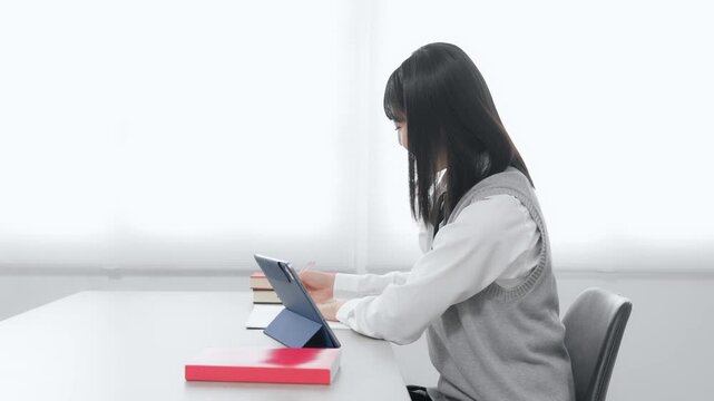 タブレットPCを使って勉強する女子学生