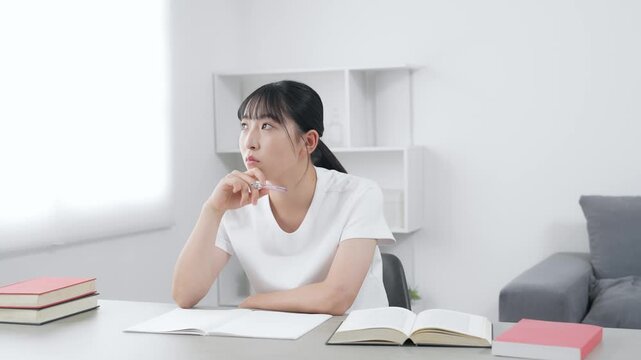 部屋で勉強する10代女性