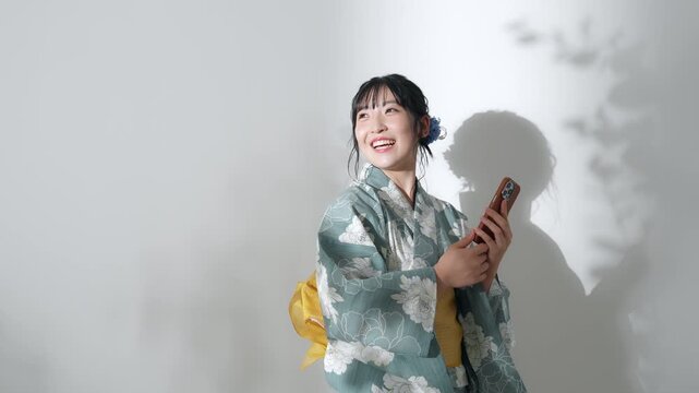 スマホを使う浴衣を着た10代女性のポートレート