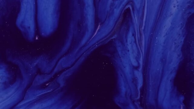 Navy ink pour. Shimmer fluid. Defocused vibrant blue pink color chemical glitter liquid sparkling texture leaking on abstract acrylic art background.