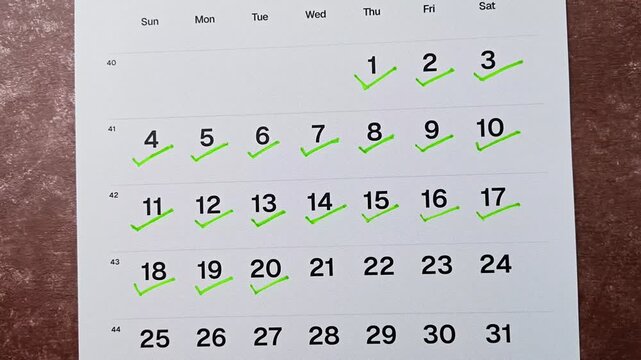 Hand putting green checkmark on calendar date 20. Goal achievement, success and task completion concept