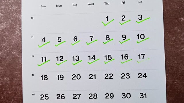 Hand putting green checkmark on calendar date 17. Goal achievement, success and task completion concept