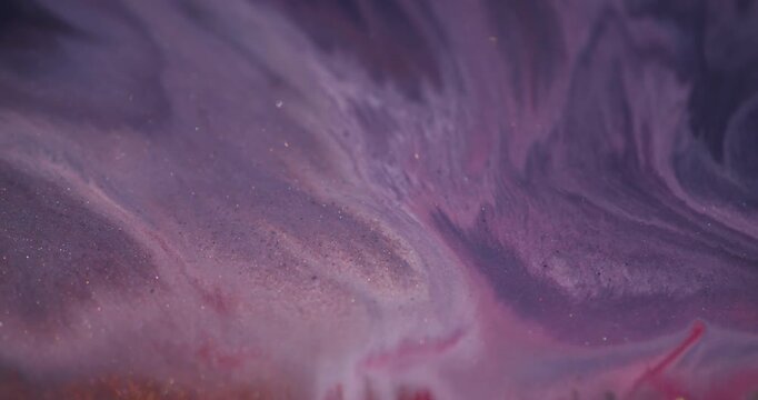 Acrylic spill defocused. Shiny liquid texture. Pink purple particles wet blending color on red paint pigment abstract art background.