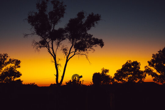 Australian outback sunset with windmill silhouette and orange sky