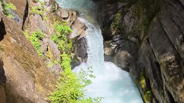 High angle view of turquoise waterfall flowing through rocky gorge in Washington