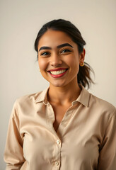 Fototapeta premium Happy young woman smiling in beige shirt with warm studio lighting