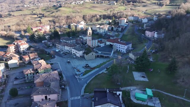 Morfasso town center and the Parish Church of San Martino Vescovo, Morfasso, Piacenza, Emilia-Romagna, Italy, surrounded by the Northern Apennines, drone pullback