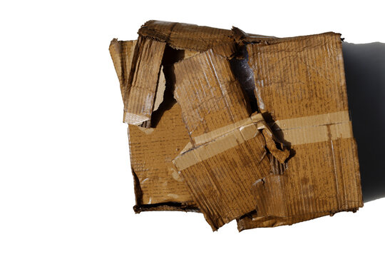 A heavily damaged, wet, and torn brown corrugated cardboard box.