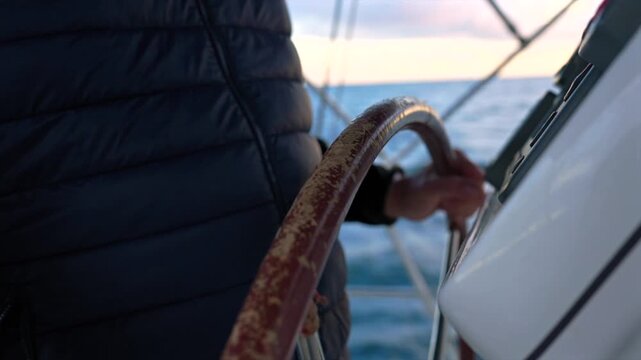 sailor holding the helm of a sailboat in the calm ocean, first-person perspective focused on the serene journey ahead with wooden helm and canvas sail against a blue sky.