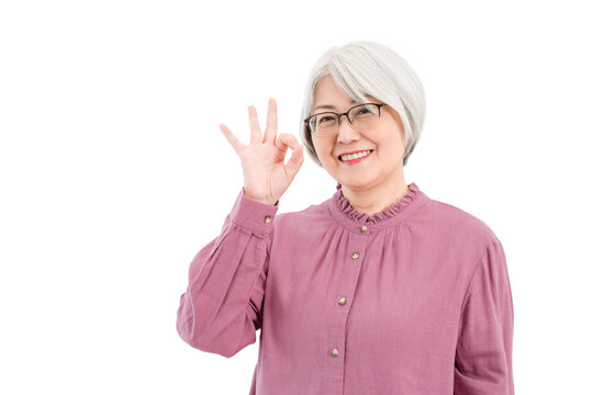 A smiling senior woman with gray/silver hair (ok, like, good, nice, successful, correct)