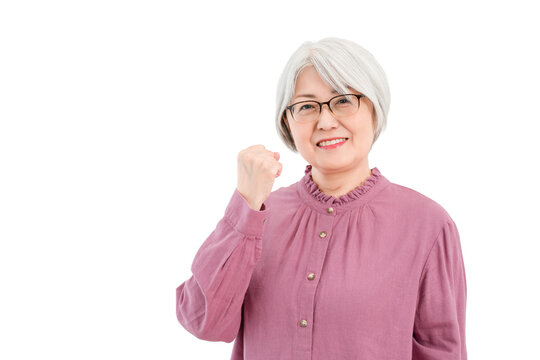 A smiling senior woman with gray/silver hair (making a victory pose, showing determination, fulfillment, and growth)