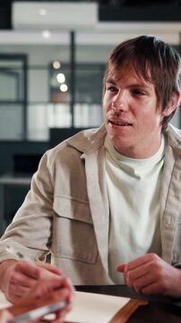 HR, man and talk with notebook in interview for hiring process, salary negotiation and questions. Office, headhunter and candidate with FAQ for talent acquisition, job opportunity or discussion notes