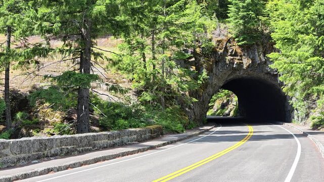 Asphalt road leading into a mountain tunnel in Washington state