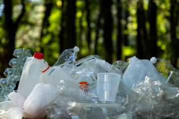 Fototapeta premium Waste trash in green nature. Waste in park. Environment and trash concept. Trash for eco recycling. Trash in nature. Plastic in pollution. Plastic and waste. Plastic for recycling.