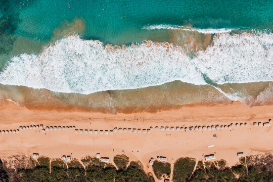 Aerial top view of the beach with waves and sun umbrellas, Fernando de Noronha, Pernambuco, Brazil