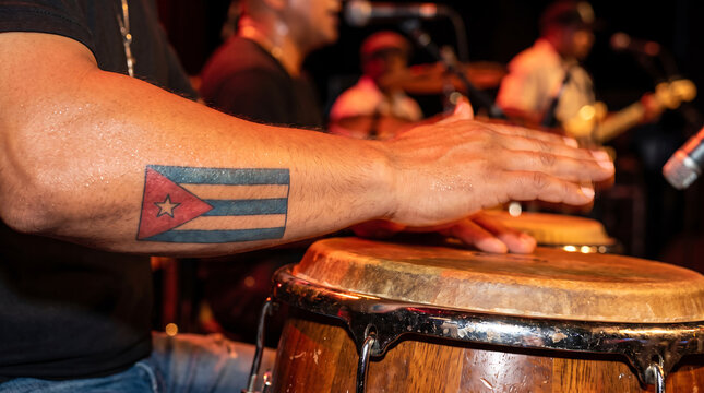 Musician with Cuba flag tattoo playing conga drum live