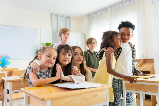 Diverse group of elementary students and teacher posing together in classroom, Happy multi-ethnic pupils and teacher with friendly atmosphere in school, Diverse student and teacher in modern classroom
