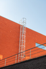 Hasselt, Belgium. Fixed safety ladder on contemporary university building with red brick facade © Dirk