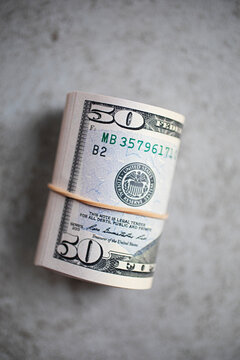 Rolled up $50 dollar bills on grey background