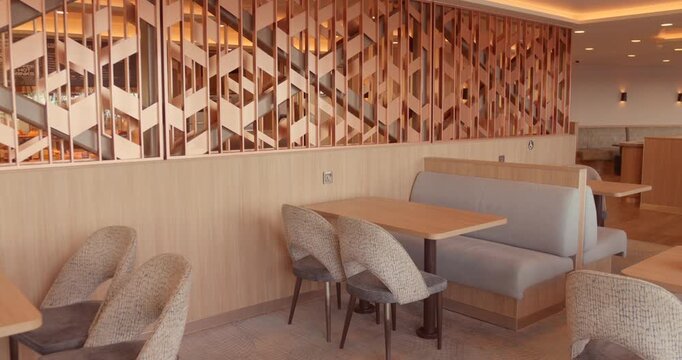 Modern ferry lounge seating area with empty tables and decorative partition wall