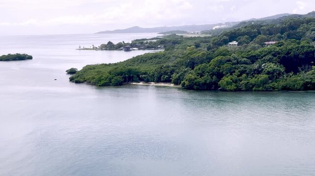 Calm Roatan harbor in Honduras shows a lush green shoreline and tropical Caribbean bay scenery.