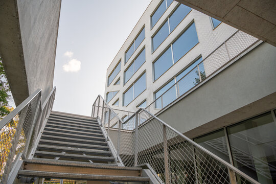 Hasselt, Belgium. Exterior steel staircase and contemporary office building with geometric architecture and glass facade